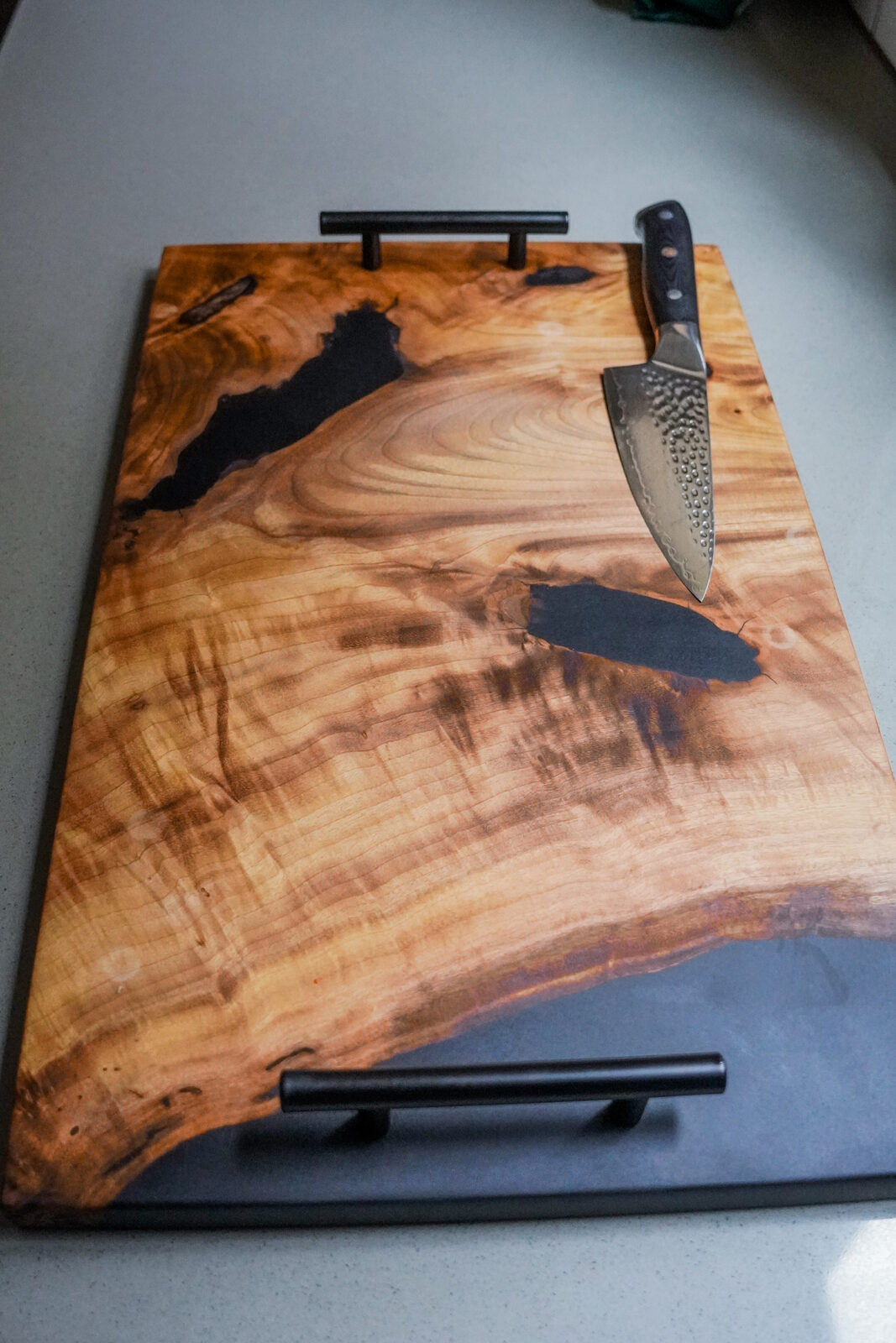 Top-down view of live-edge board with damascus knife